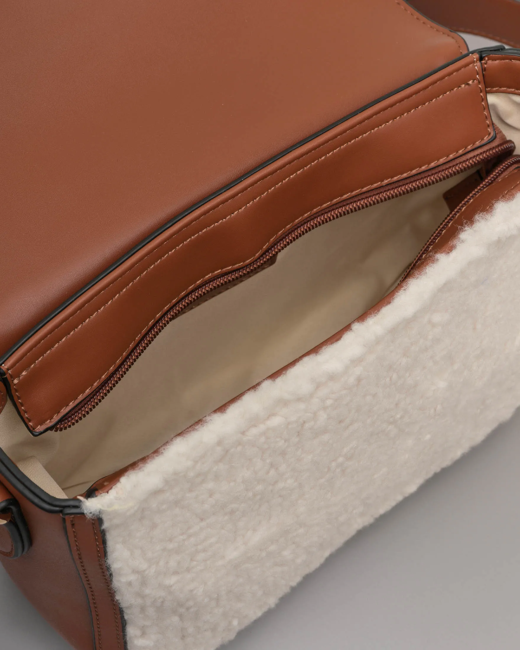 Borsa color cuoio in similpelle liscia con davantino in shearling bianco