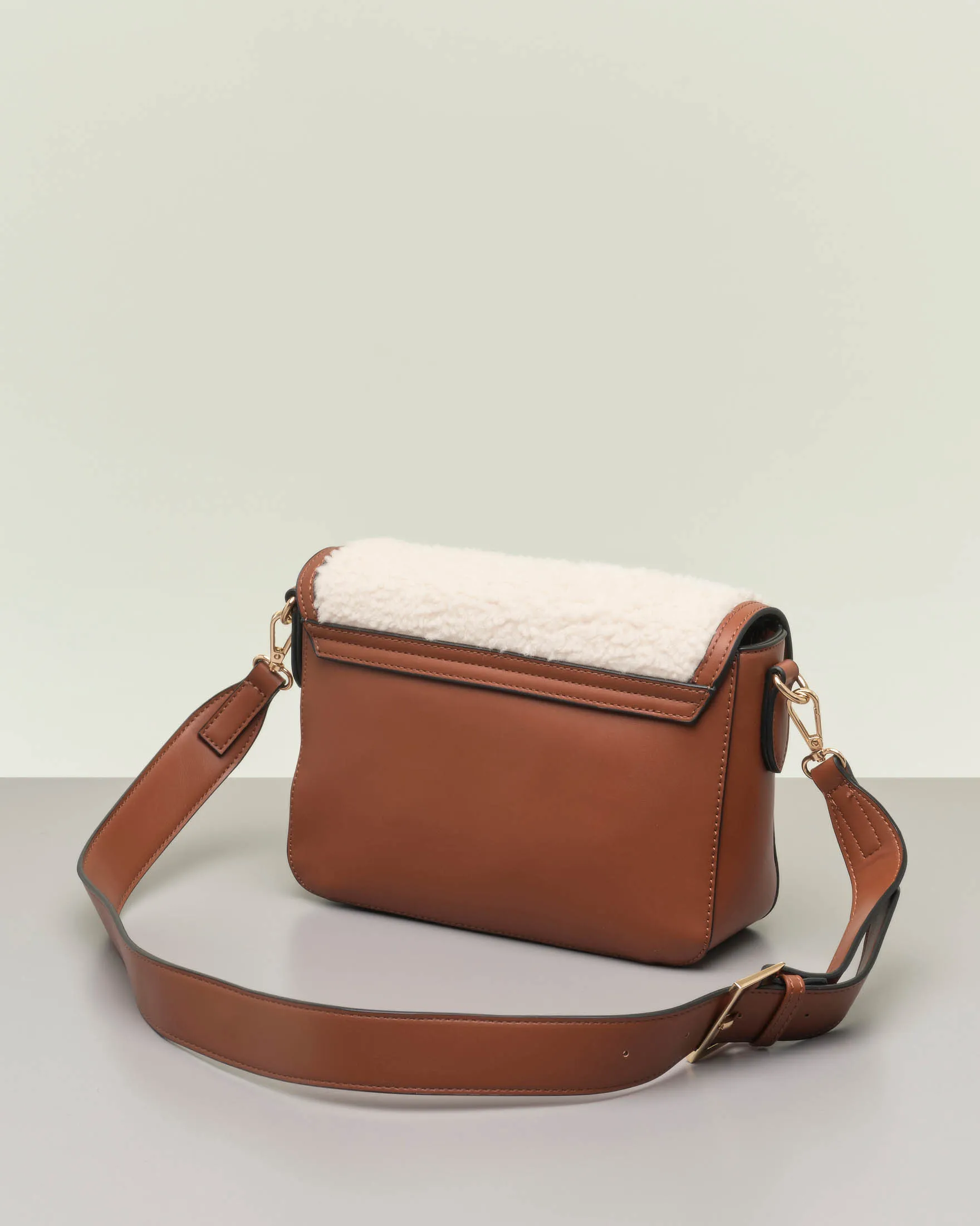 Borsa color cuoio in similpelle liscia con davantino in shearling bianco